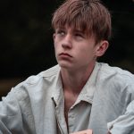 Oliver Twist holding a sign with his name on waiting to be taken as an apprentice