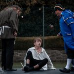 Mr Bumble and a workhouse assistant looking down on Oliver Twist